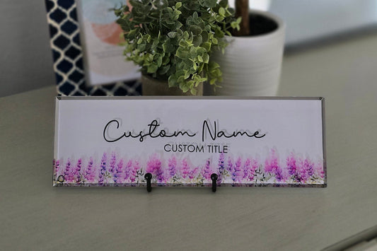 Decorative nameplate with floral design and customizable text on a surface.