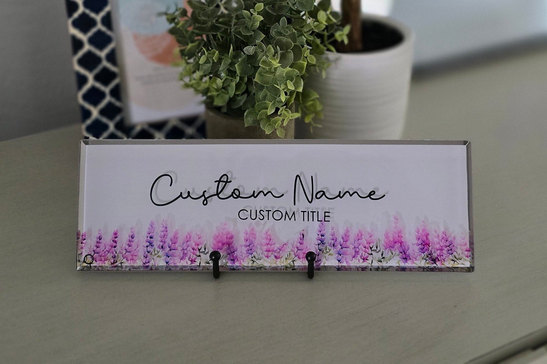 Decorative nameplate with floral design and customizable text on a surface.